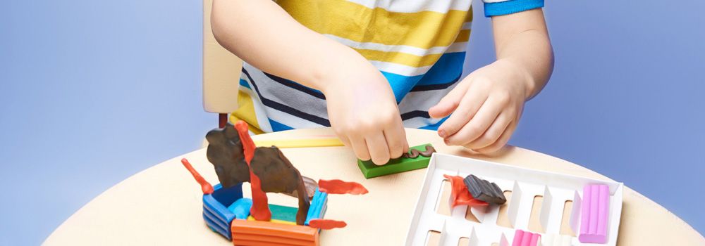 petit garçon en train de jouer avec des pâtes à modeler