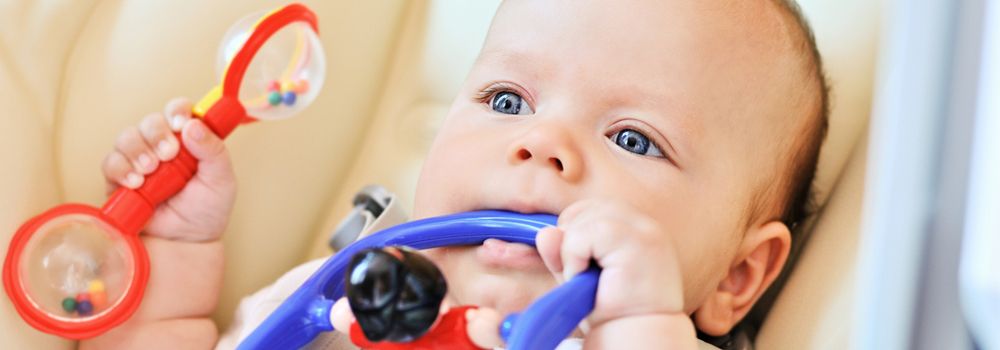 bébé jouant avec son anneau de dentition