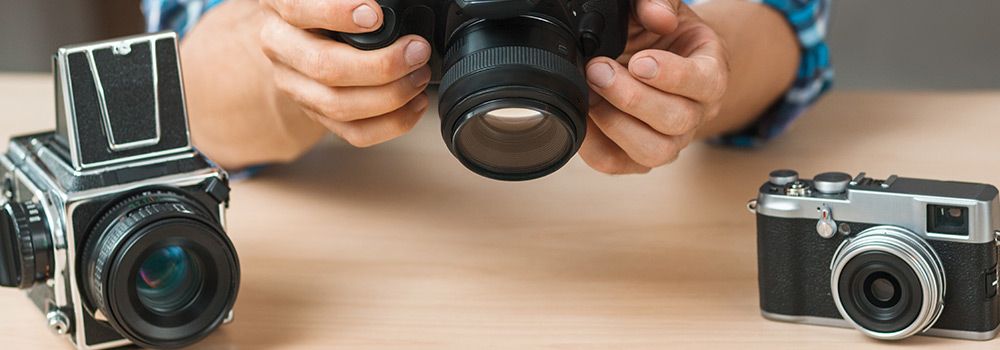 Un homme compare plusieurs appareils photo