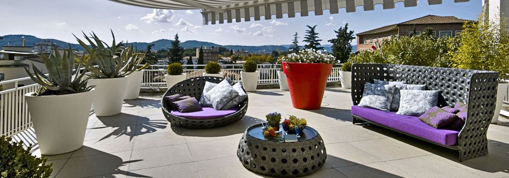 terrasse en hauteur mobilier tressé et grandes pots de fleurs