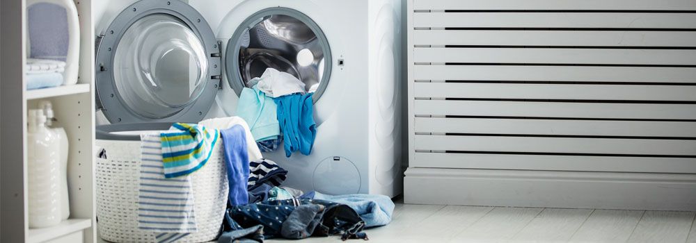 femme indécise devant lave-linge