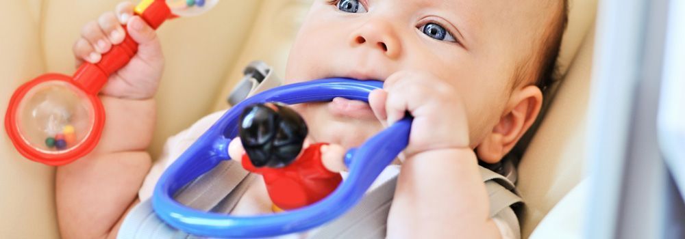bébé avec son anneau de dentition bleu