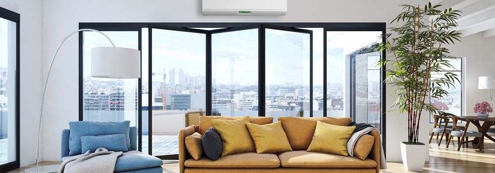 climatiseur, canapé, fauteuil bleu, lampadaire, coussins, baie vitrée