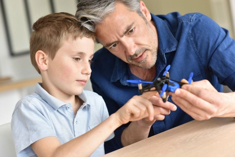 pere fils joue avec mini drone pere fils joue avec mini drone