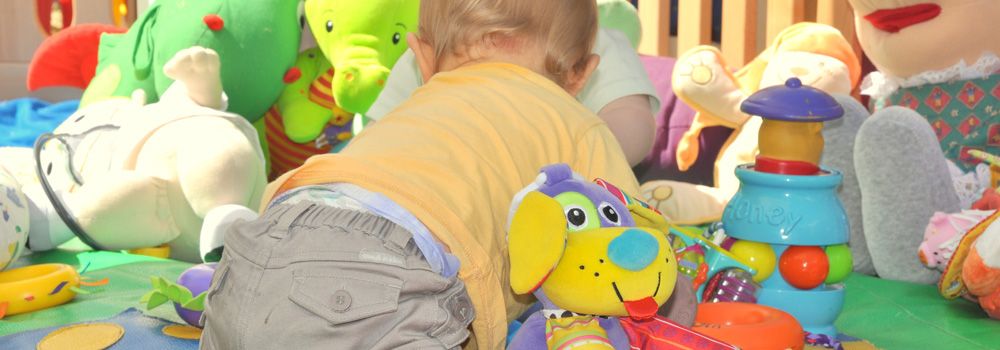 bébé avec ses jouets dans son parc