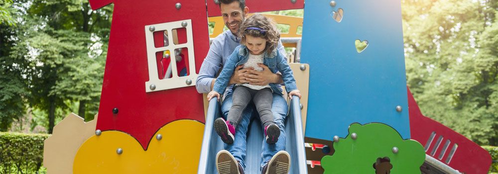père et fille glissant sur un toboggan